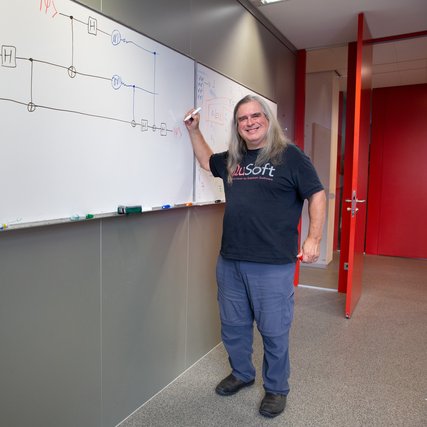 Gilles Brassard in front of quantum teleportation formula