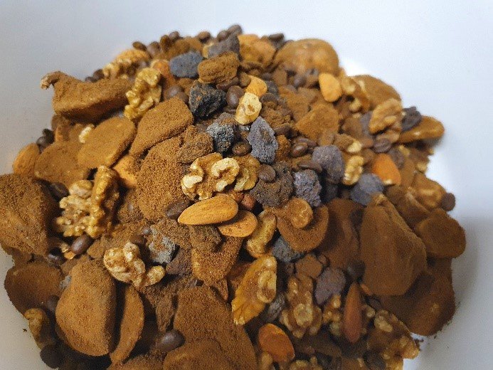 The final sample mix consisting of almonds, dried banana chips, coffee beans, dried figs, lava stones, raisins, and walnuts immersed in cereal-based coffee powder as a filler material.