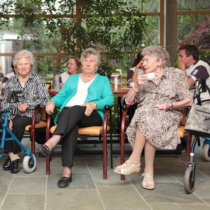Ouderen zitten bij elkaar in een zorginstelling