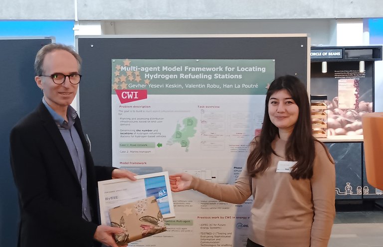Gevher Yesevi Keskin receives the PhD poster award, standing in front of the winning poster