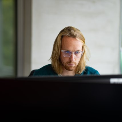 Marten Folkertsma (A&C and QuSoft) behind his computer. Picture by Ivar Pel for CWI, 2022.