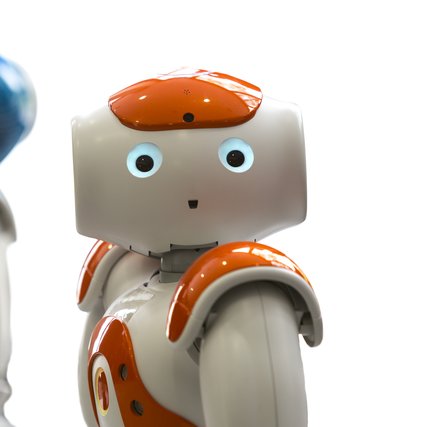 Small robots with human face and body - humanoid. Artificial Intelligence - AI. Orange and blue robots isolated on white background.