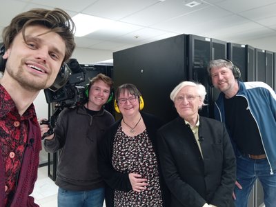 Filming for the NOS news broadcast at CWI on 24 April 2026, for forty years of .nl on 26 April 2026 in the server room of the CWI, with Milo Hornstra (NOS), cameraman Jesse de Roos, Annette Kik, Steven Pemberton, and Emil Gorter.