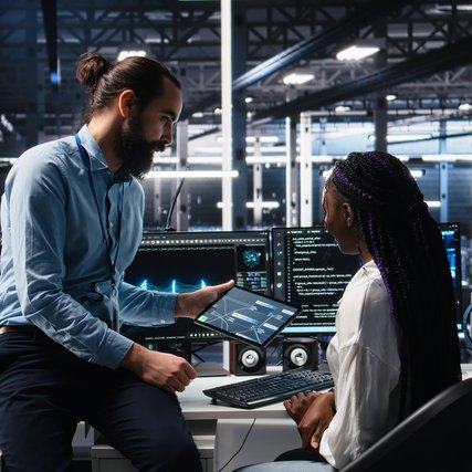System administrator and employee in data center coding with generative AI. Team leader and IT worker leveraging artificial intelligence large language model tech in server hub.