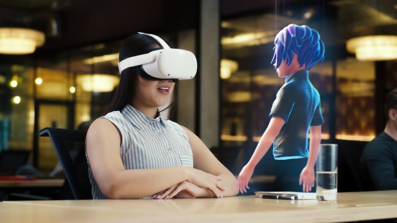 Young woman wearing VR headset conversing with a cartoon character avatar via an futuristic screen hologram.