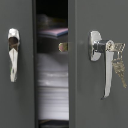 Closeup of steel filing cabinet with the keys.